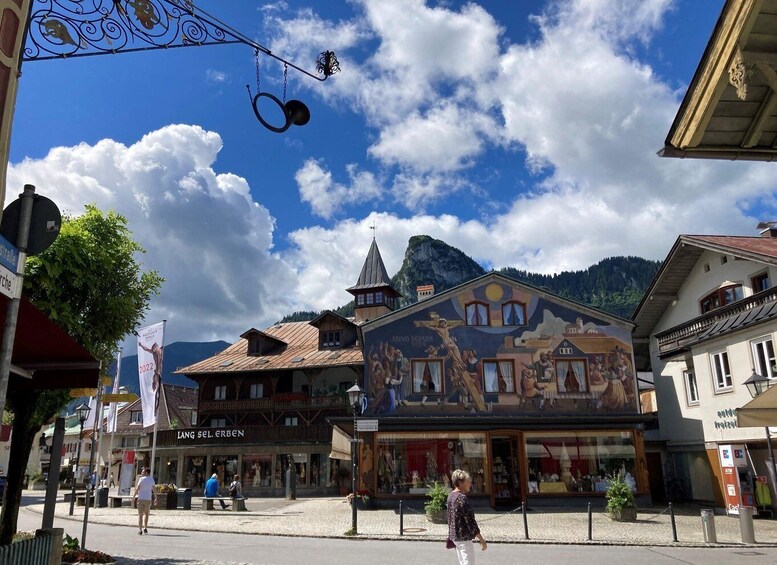 A town square with buildings, a church, and mountains in the background. 4