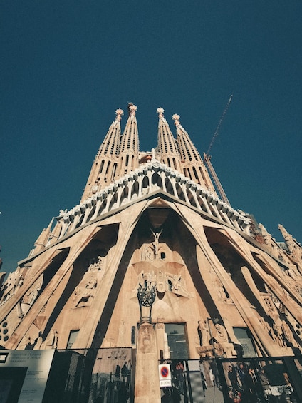The Sagrada Familia's facade with intricate sculptures and a prominent entrance gate. 2