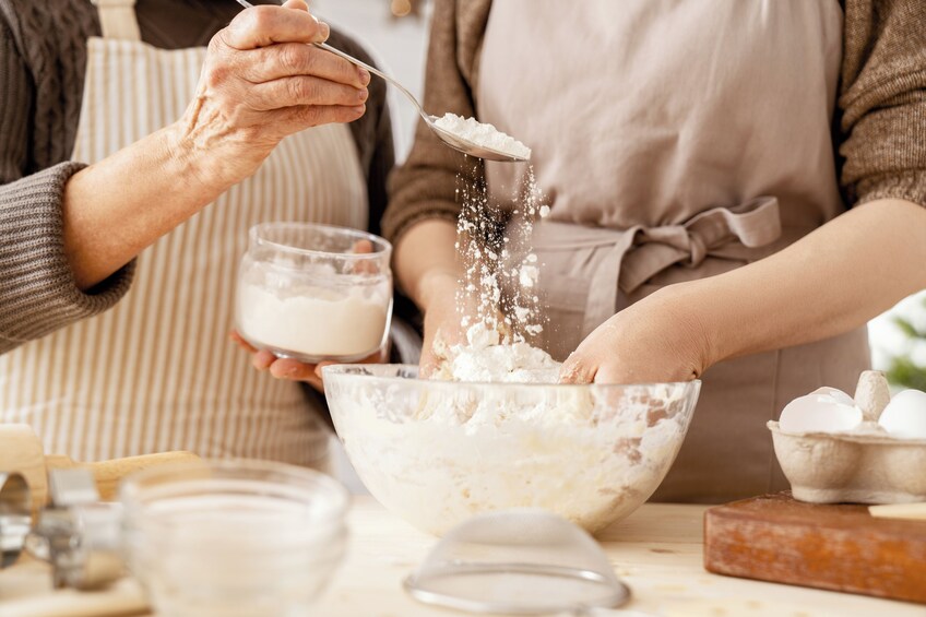 An elderly person mixing ingredients in a bowl with a spoon. 3
