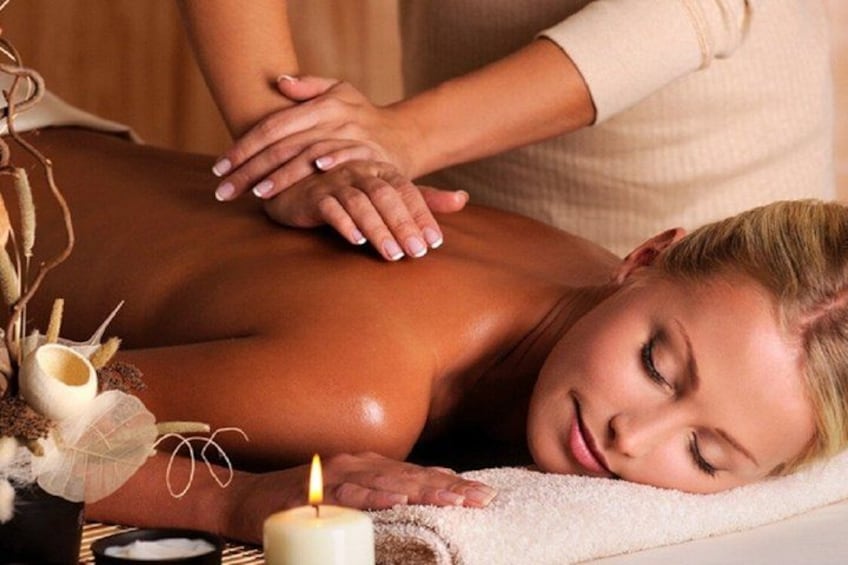 Une personne recevant un massage du dos à l’aide d’une bougie et d’éléments décoratifs. 3