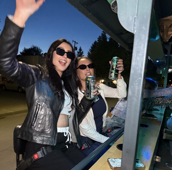 Two people in a vehicle, one holding a can. 2