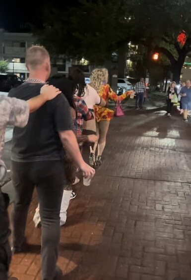 A nighttime street scene with people walking pedestrians. 5