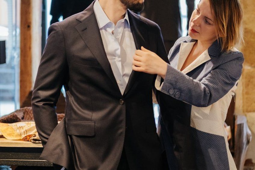 A person adjusting another person's suit jacket. 3