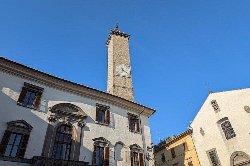 A historic building with a clock tower, arched windows, and a clear blue sky. 3