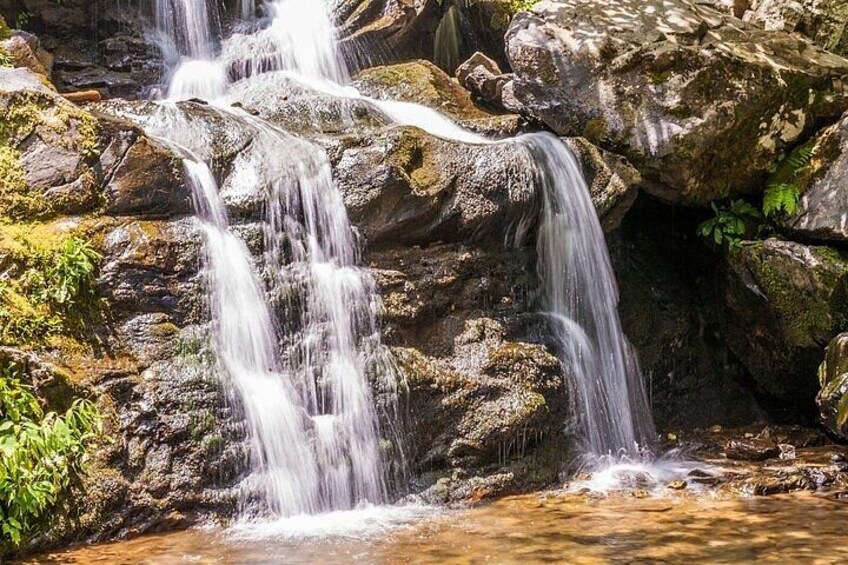 A waterfall cascading over rocks in a natural setting. 2