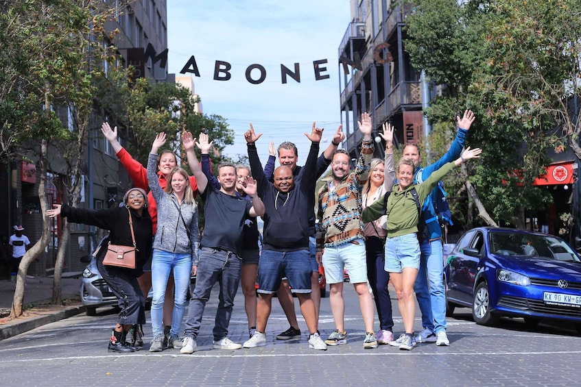 A group of people posing in front of a building with 'ABONE' written on it. 1