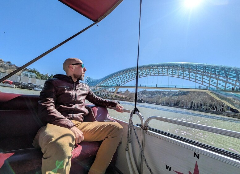 A person on a boat with a modern bridge in the background. 5