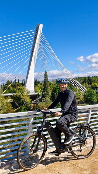 A person riding a bicycle with a white bridge in the background. 3