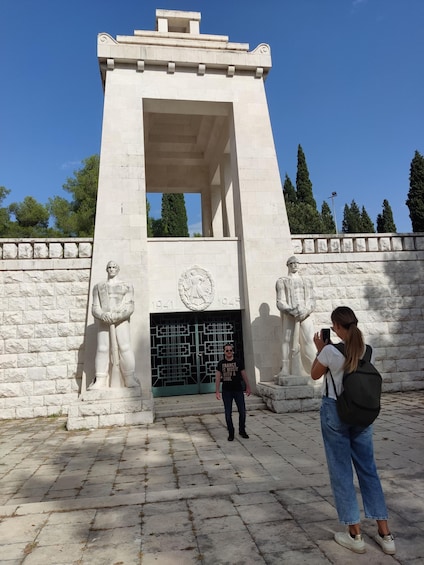 A monument with a central door and two statues on either side. 5