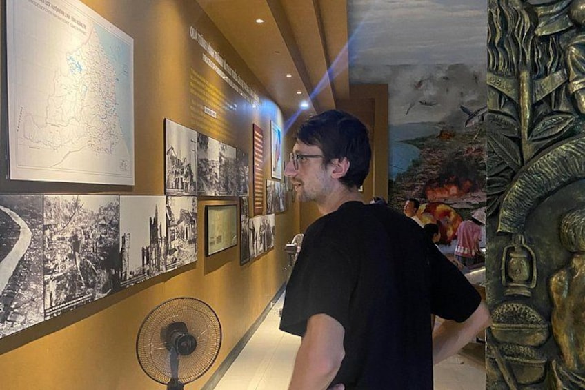 En museiutställning med en karta, fotografier och en skulptur. 4