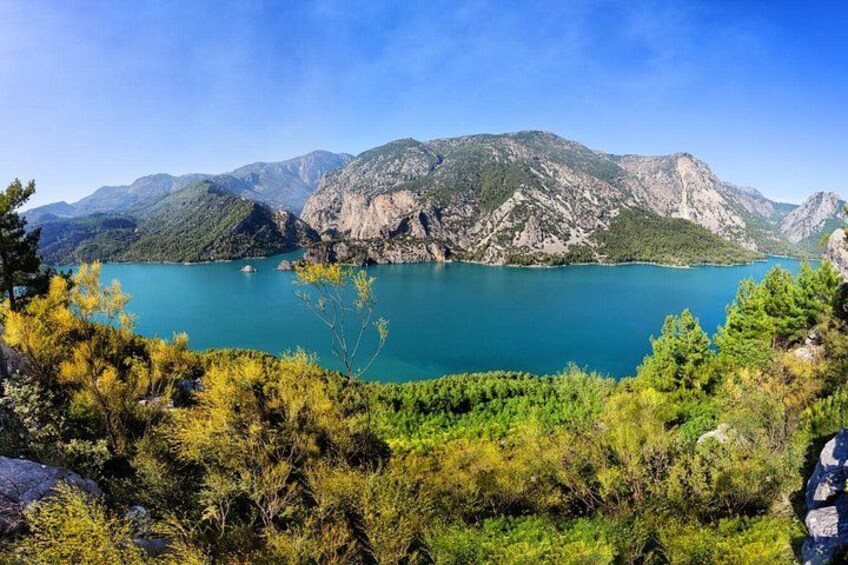 A lake surrounded by mountains, with trees in the foreground. 3