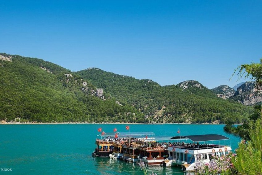 A boat docked at a pier with a mountainous backdrop. 5