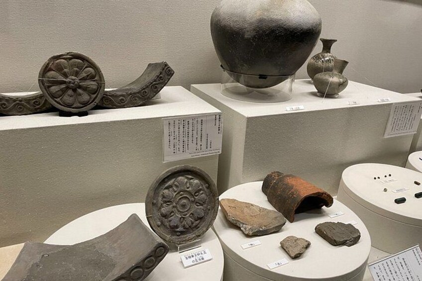 Ancient pottery and artifacts displayed on pedestals in a museum. 2