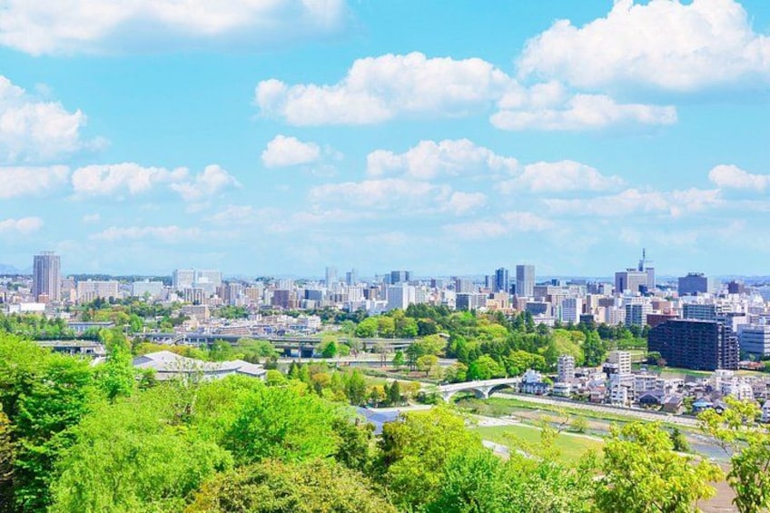 A cityscape with a river, green parks, and a clear sky. 2