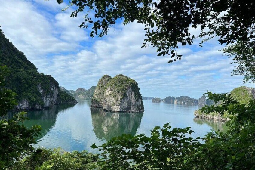 A calm bay with limestone islands surrounded by lush greenery and clear blue water. 2