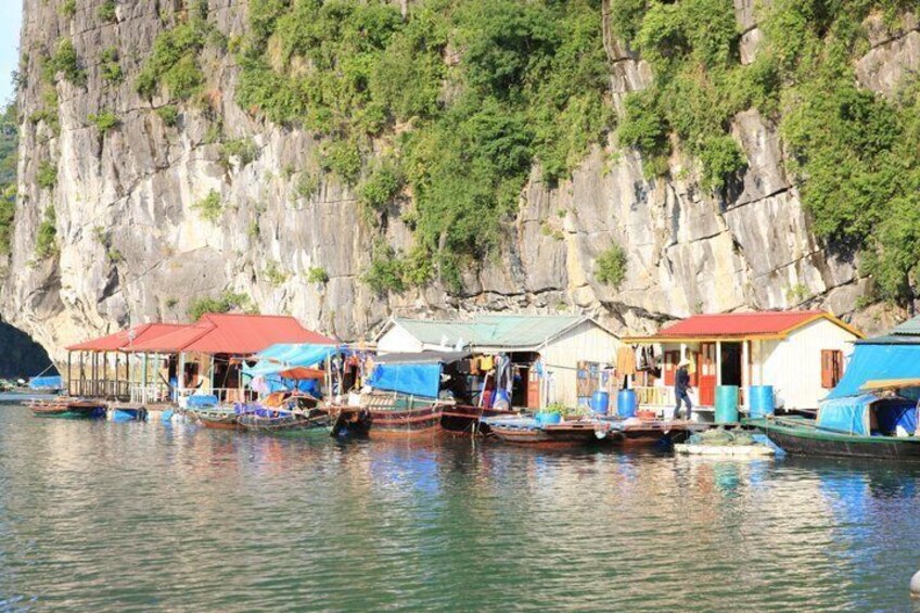 A calm river with boats docked at a pier, surrounded by steep cliffs and lush greenery. 3