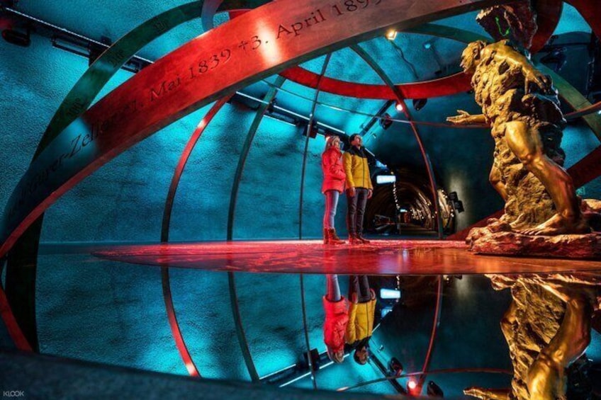A reflective sculpture with inscriptions and a circular ceiling structure. 4