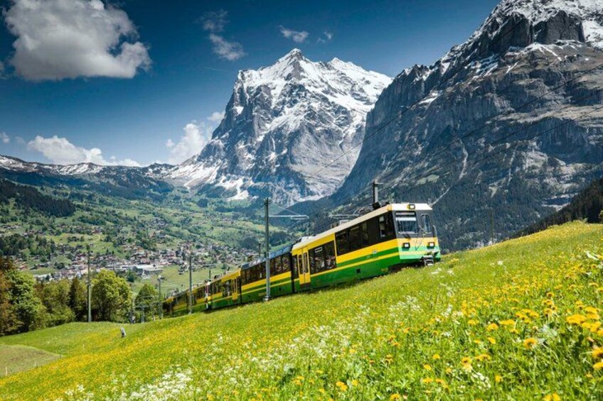 A train on a track with a mountainous landscape in the background. 2