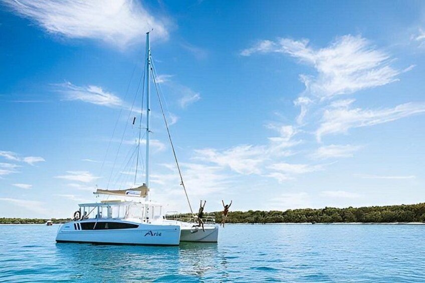 A sailboat on calm water with a clear sky and distant shoreline. 2