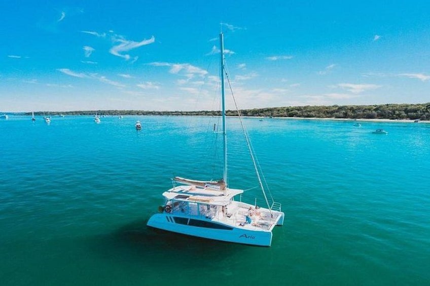 A sailboat on turquoise water with a clear sky. 1
