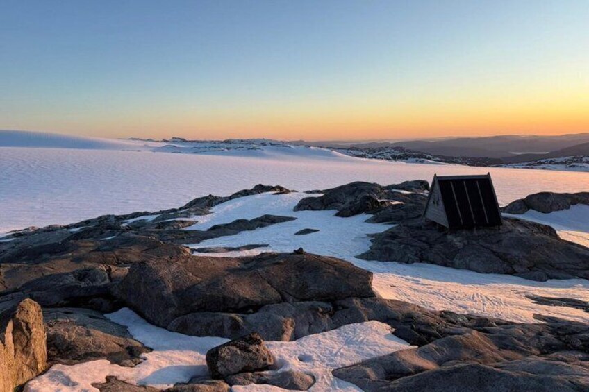 A snowy landscape with a solar panel on rocks. 1