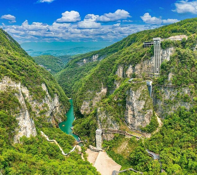 A mountainous landscape with a river, a bridge, and a building on a cliff. 2