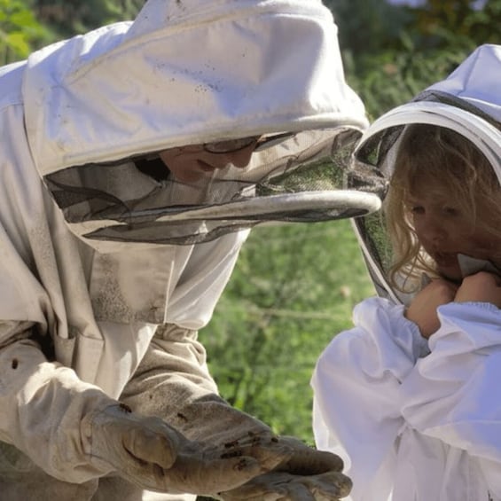 A person in protective clothing handling a small object. 1