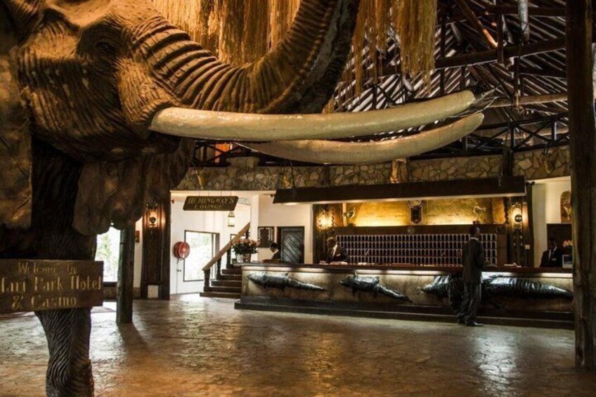 A lobby with a large elephant sculpture, a reception desk, and a staircase. 5