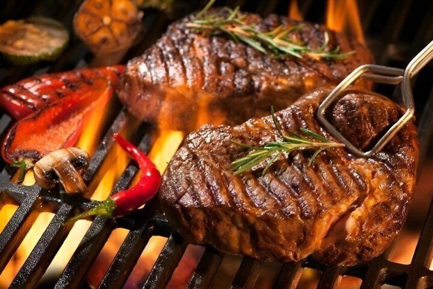 A steak being grilled with vegetables and herbs. 2