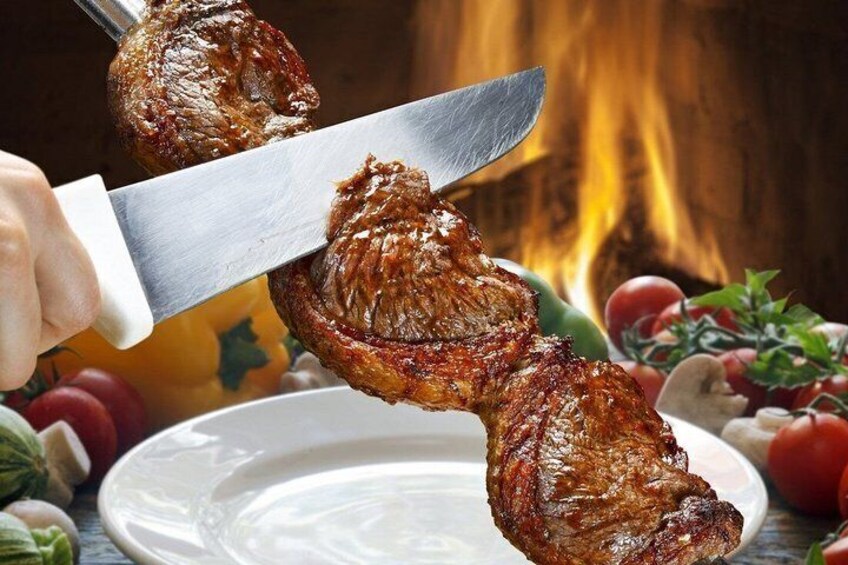 A grilled steak being sliced with a knife. 3