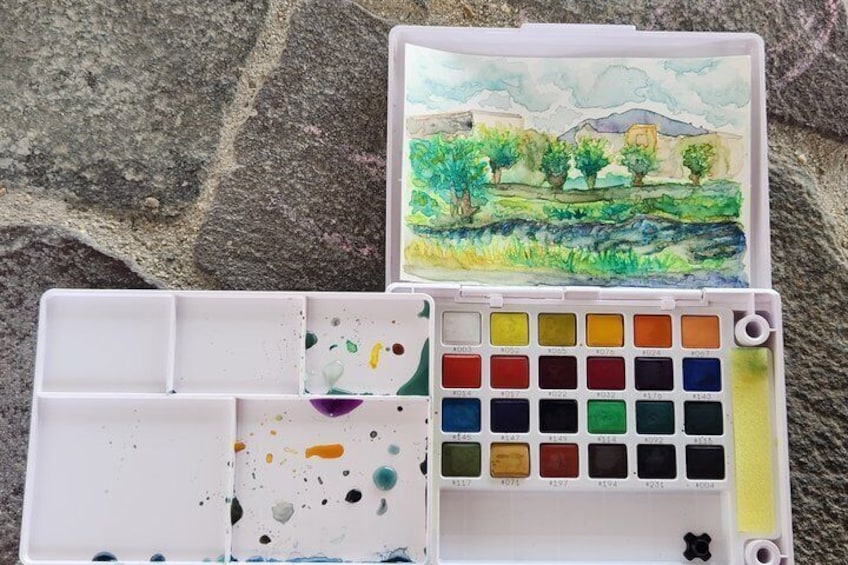 Eine Wasserfarbpalette mit verschiedenen Farben und ein Aquarellbild einer Landschaft. 1