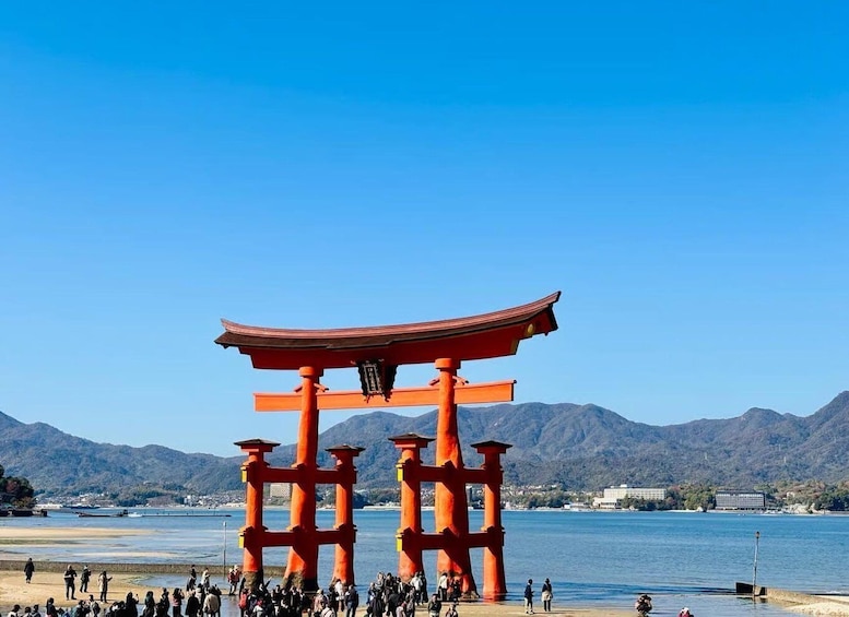 A red torii gate with a clear blue sky and mountains in the background. 1
