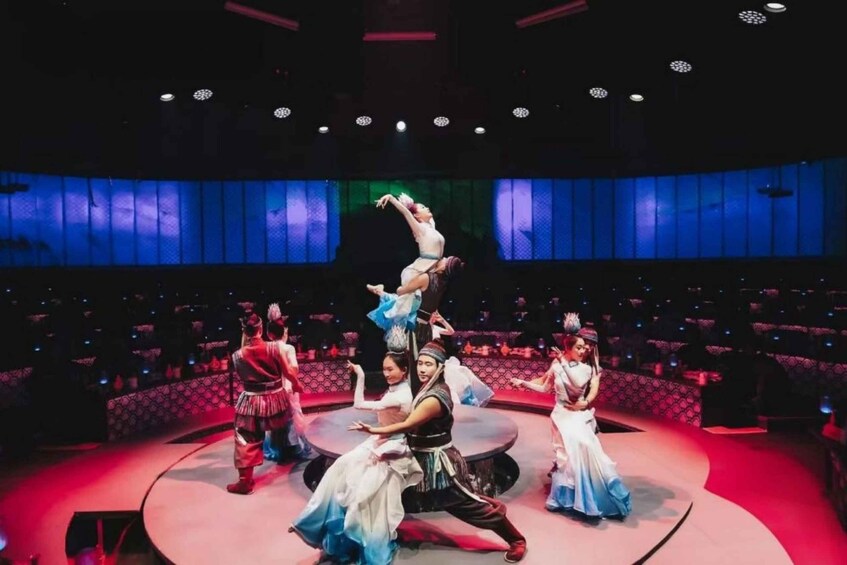 A stage with dancers in traditional costumes performing a dance. 1