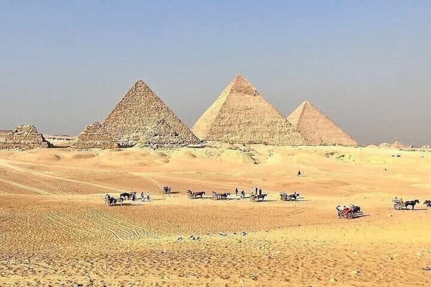 Las grandes pirámides de Giza en el desierto, con camellos y turistas. 5