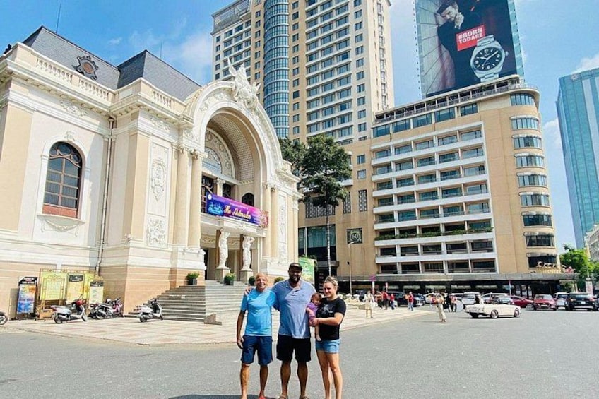 Un edificio histórico con arquitectura ornamentada, un moderno rascacielos y una calle concurrida con peatones y vehículos. 2