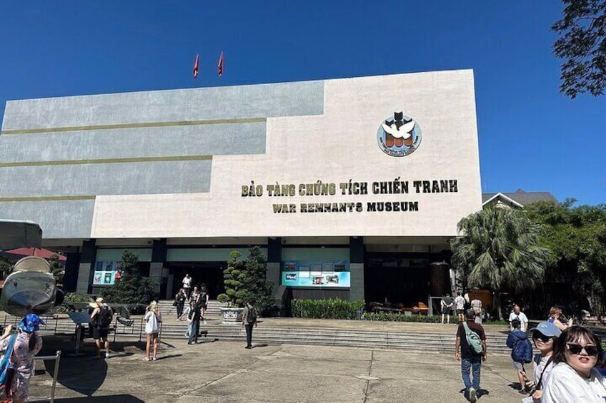 Un bâtiment orné d’un grand emblème et sur lequel on peut lire l’inscription « Bảo Tàng Chiến Tranh » sur la façade. 1