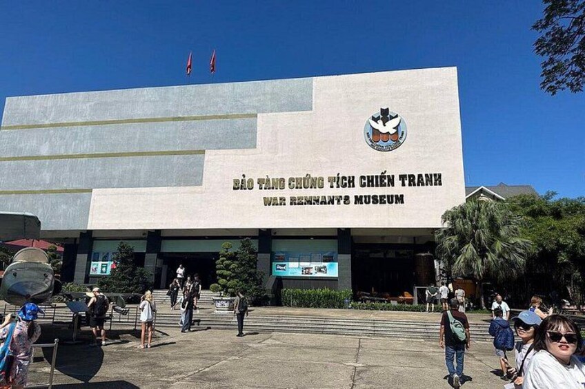 Un edificio con un gran emblema y el texto 'Bảo Tàng Chiến Tranh' en la fachada. 1
