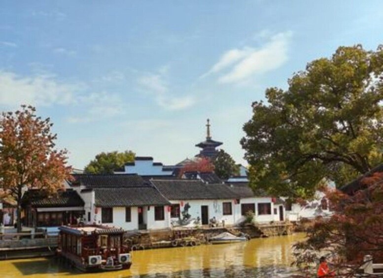 A traditional Chinese building by a river with a pagoda in the background. 3