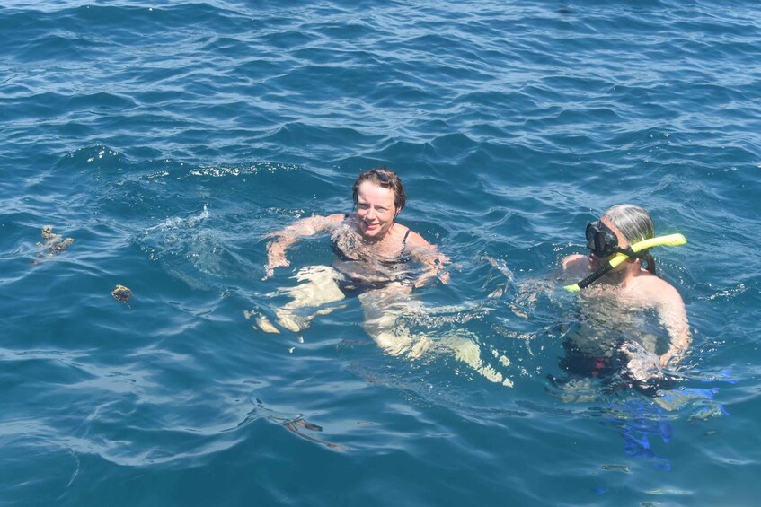 Two people swimming in the ocean. 5