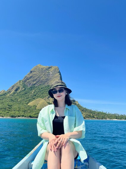 A person sitting on a boat with a mountainous landscape in the background. 4