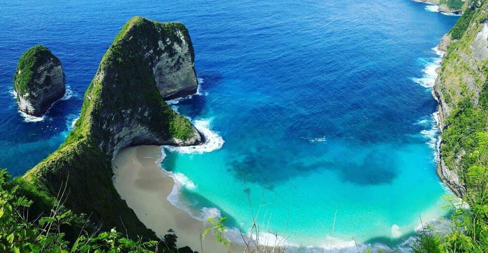 A coastal landscape with clear turquoise waters, rocky formations, and lush greenery. 2