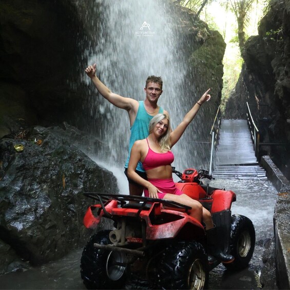 A waterfall, a person in a red outfit, and a red ATV. 4