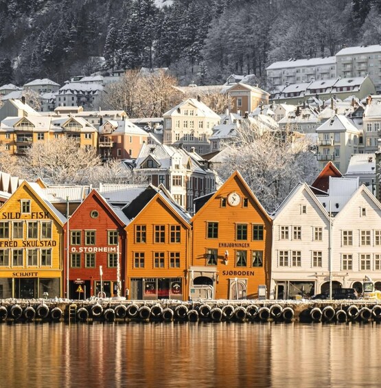 A waterfront with colorful wooden buildings, including 'SILD-FISK' and 'O.STORHEIM.' 4