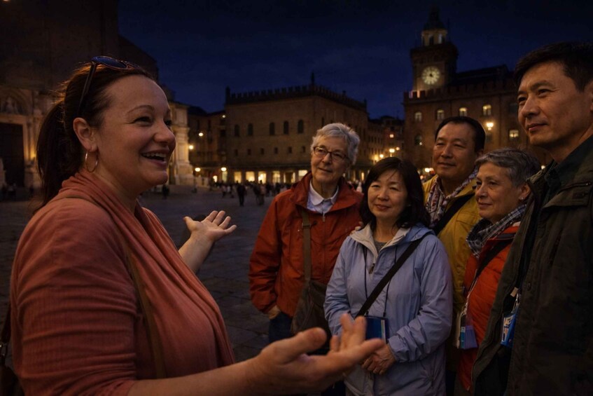 A group of people standing in a square with historic buildings in the background. 3