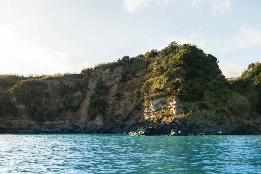 A coastal landscape with a rocky cliff and a body of water. 4