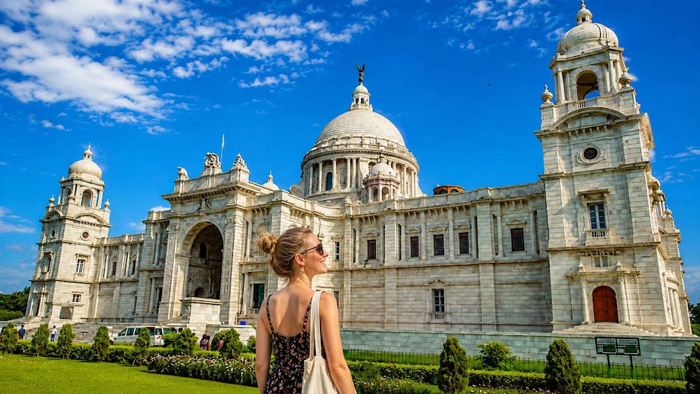 A large, historic building with domes and towers, surrounded by well-maintained gardens. 1