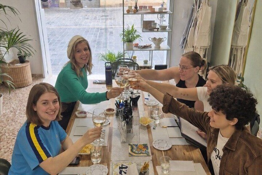 A group of people toasting at a table with wine glasses. 3