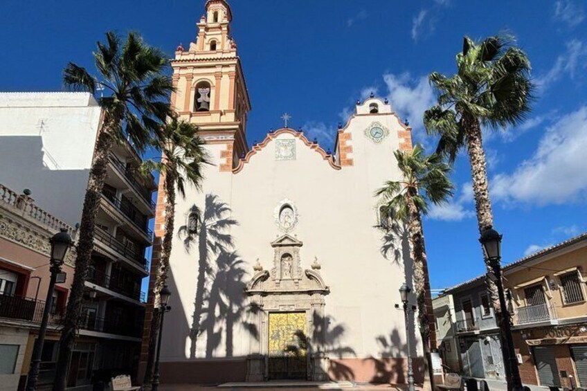 A church with a bell tower, palm trees, and a clear blue sky. 4