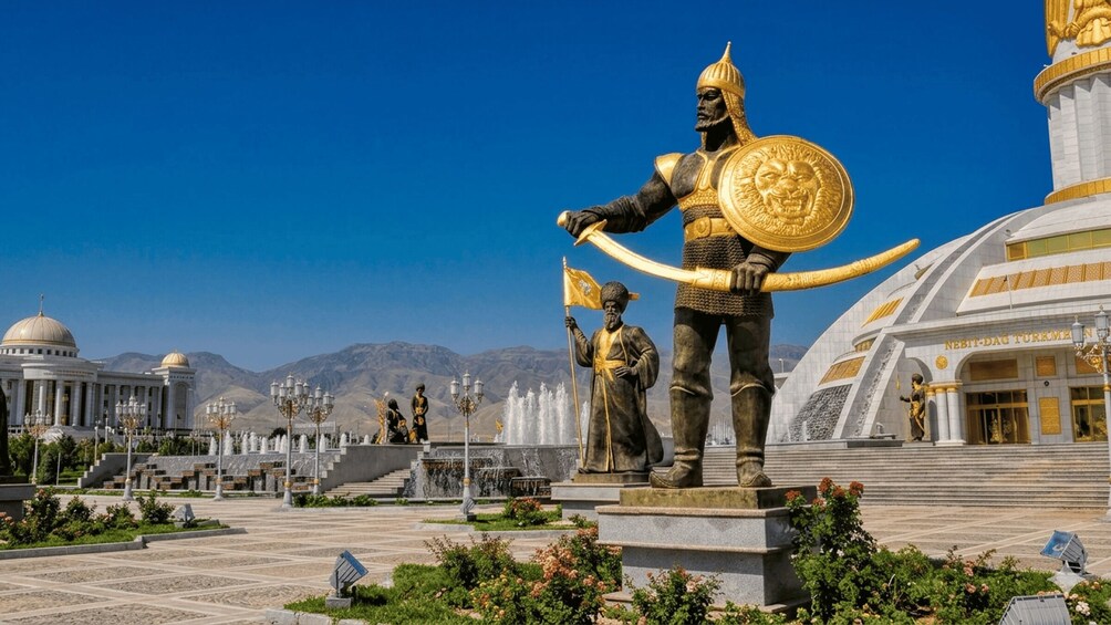 A statue of a warrior holding a shield and a flag, with a building labeled 'Nesit-Dag Turkmenistan' in the background. 1