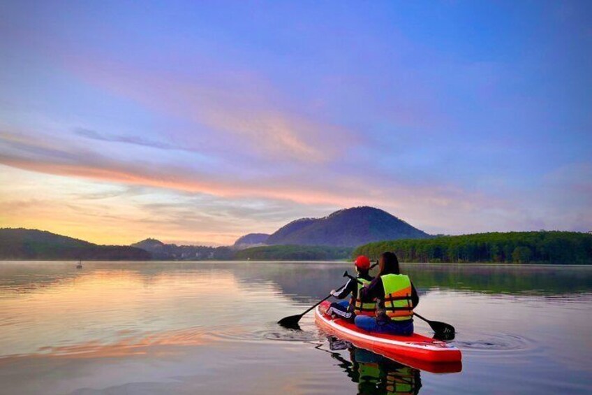 A person kayaking on a calm lake with mountains in the background. 2